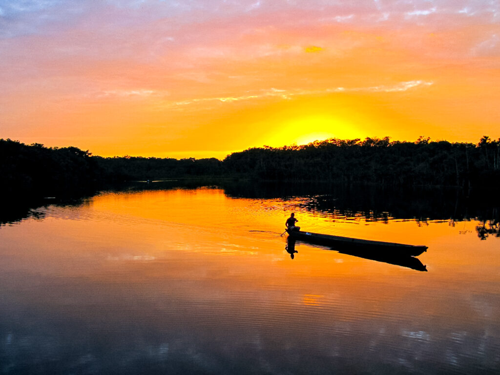 Sonnenuntergang mit einem Boot mit einer Person auf dem See