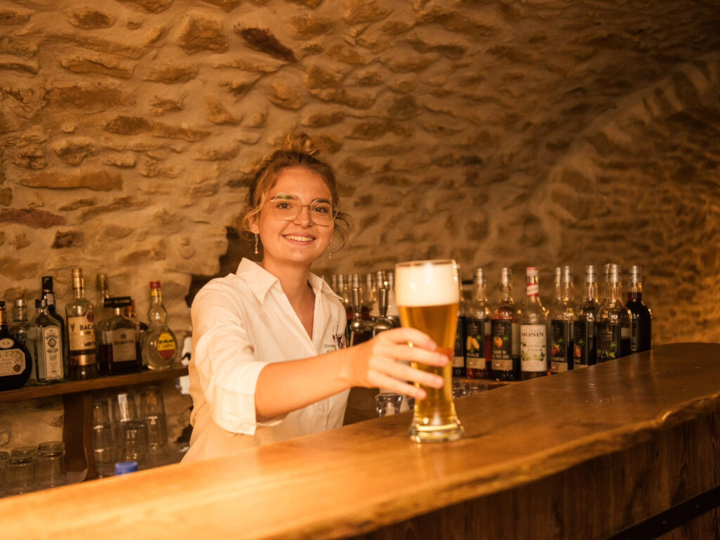 Kellnerin hinter der Bar serviert ein Bier