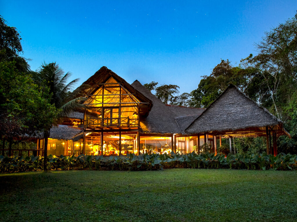 Lodge mit Strohdach und Licht beim eindunkeln