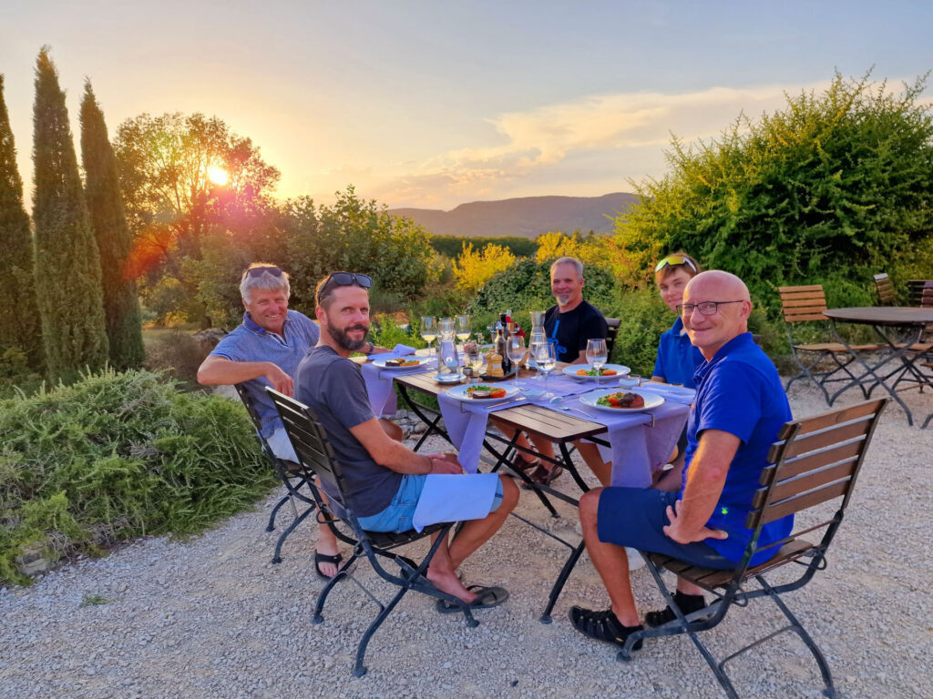 5 Reisende beim Abendessen mit Sonnenuntergang